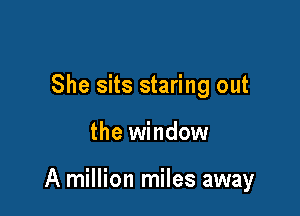 She sits staring out

the window

A million miles away