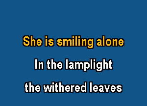 She is smiling alone

In the lamplight

the withered leaves