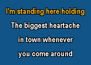 I'm standing here holding

The biggest heartache
in town whenever

you come around
