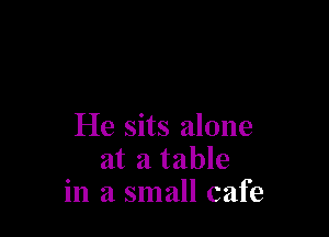 He sits alone
at a table
in a small cafe