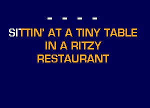 SI'I'I'IN' AT A TINY TABLE
IN A RITZY

RESTAURANT