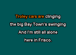 Troley cars are clinging

the big Bay Town's swinging

And I'm still all alone

here in Frisco.