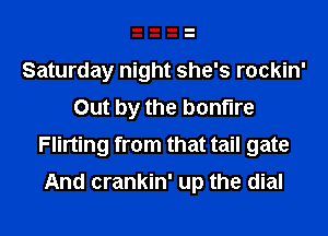 Saturday night she's rockin'
Out by the bonfire
Flirting from that tail gate

And crankin' up the dial