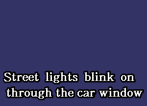 Street lights blink on
through the car Window