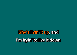 She's livin' it up, and

I'm tryin' to live it down