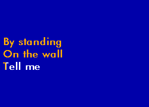 By standing

On the wall

Tell me