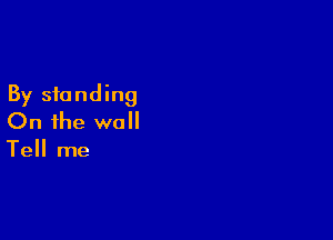 By standing

On the wall

Tell me