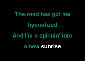 The road has got me

hypnotized
And I'm a-spinnin' into

a new sunrise